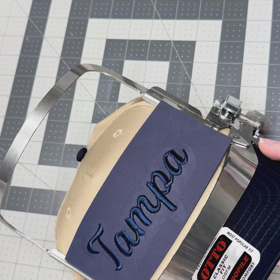 Pulling off the puff sheet on a newly embroidered Tampa hat